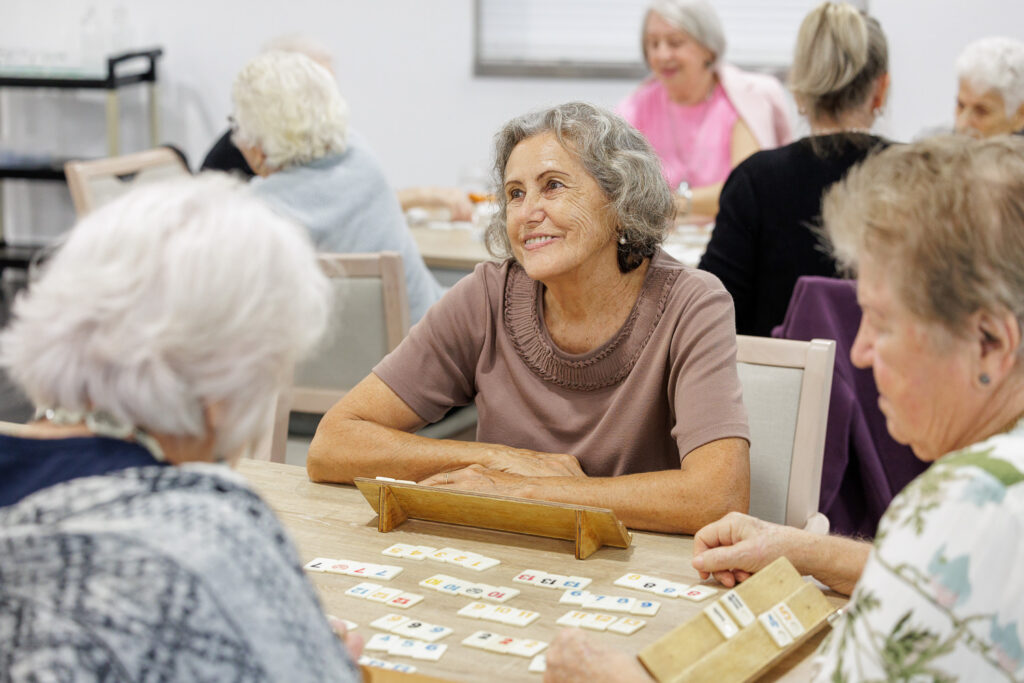 Older women enjoying a group tile game at CÜRA’s Wellness and Activity Centre
